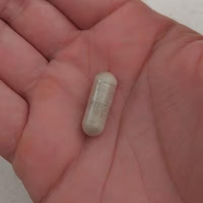 Close-up of a single Vita Boost Max vegetable capsule held in a palm, emphasizing the easy-to-swallow design for nightly use.