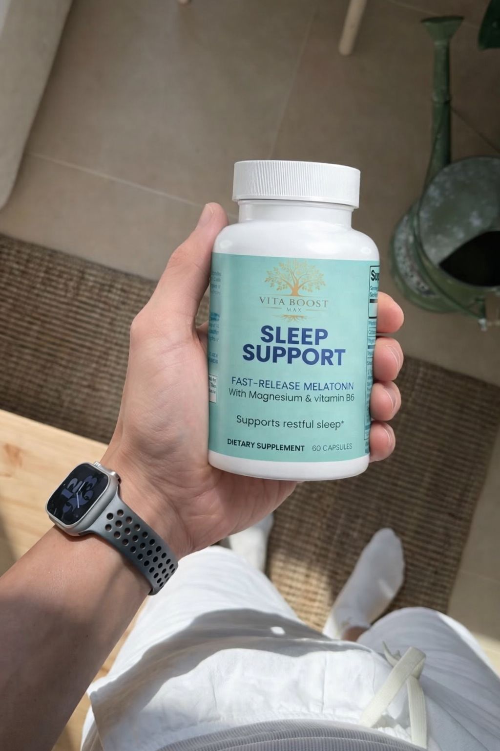 A customer holding a bottle of Vita Boost Max Sleep Support while wearing a smartwatch, tracking their improved sleep quality and wellness routine.